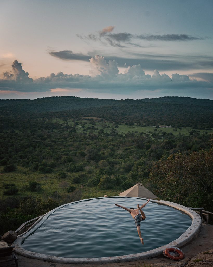 A tourist diving into the Mihingo Lodge Swimming Pool